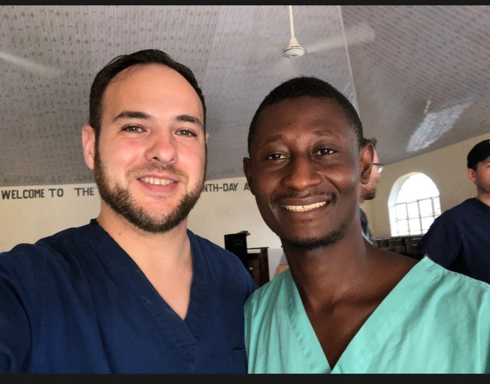 Iván and John, both in scrubs, at the mission site in Sierra Leone in 2019